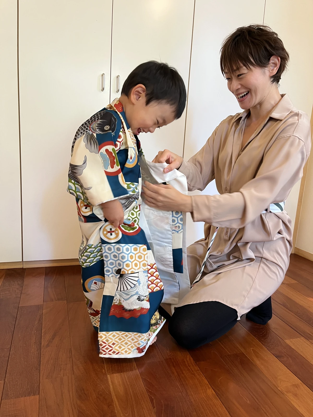 但野 美穂子が七五三の男の子に着付けをしている様子